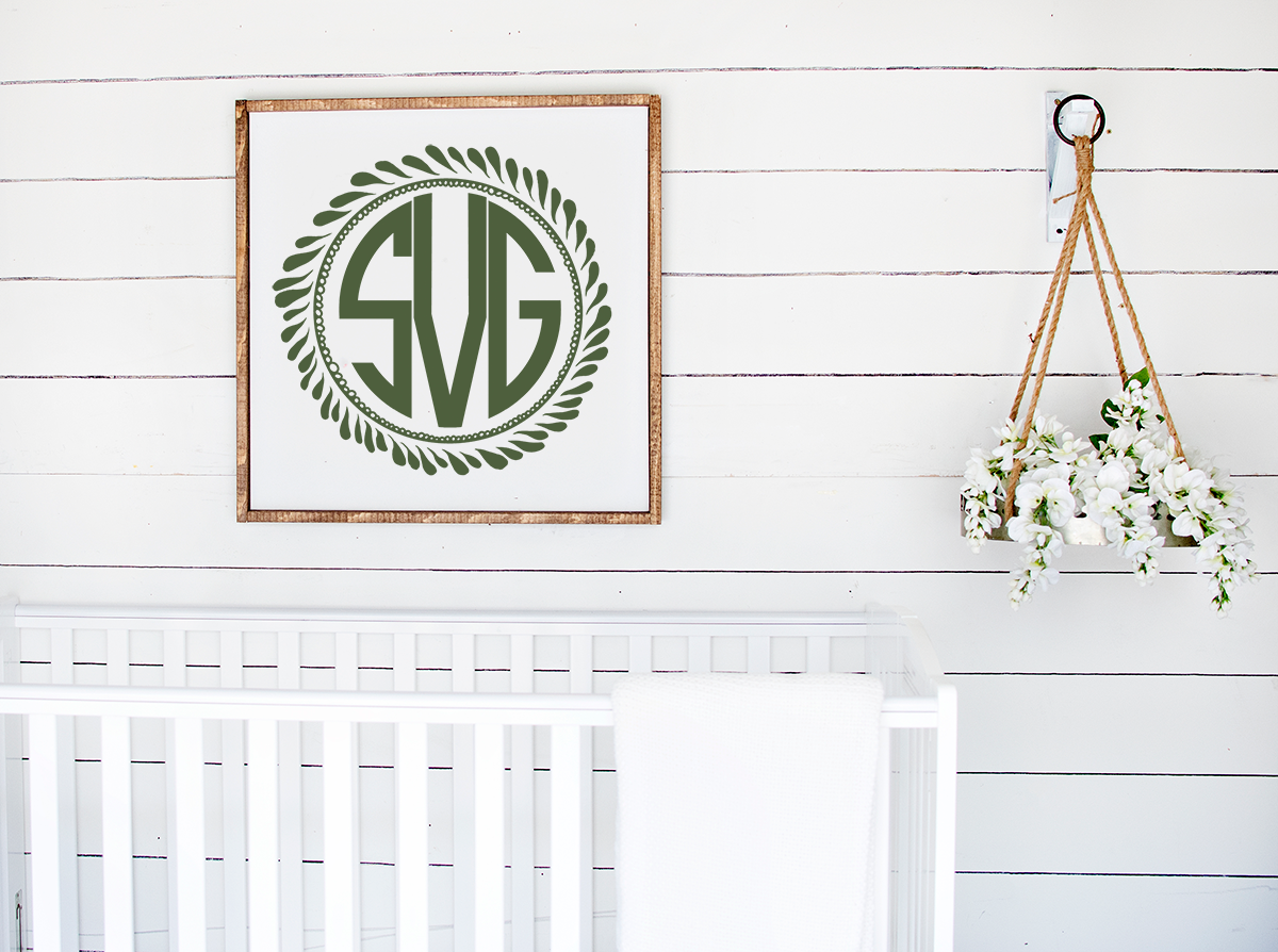monogram wreath framed above a white crib